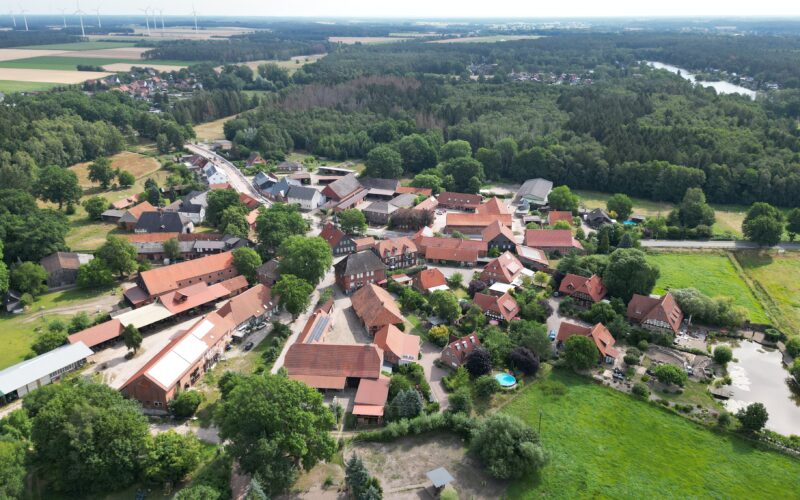 Luftbild vom Rundlingsdorf Bokensdorf. Das Gebäude in der Mitte mit dem Glockenturm beherbergt das Gemeindebüro und den Kindergarten.